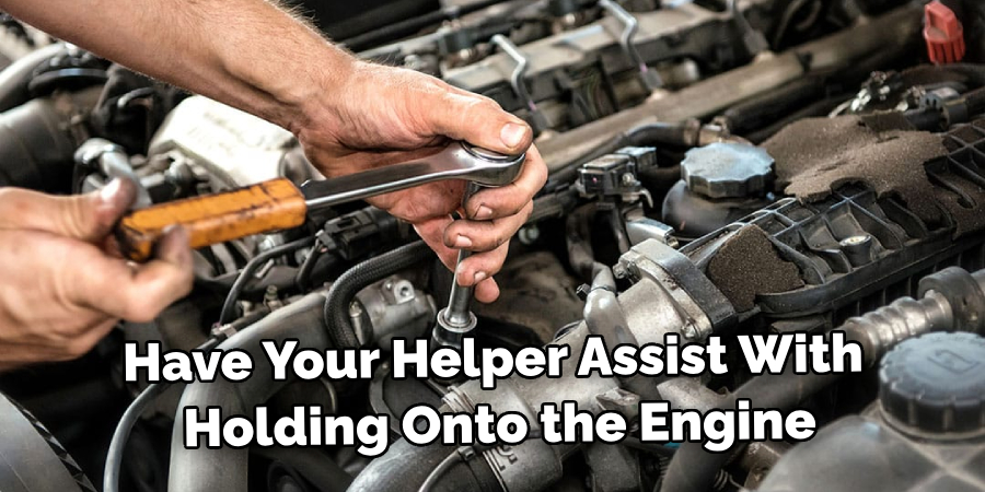 Have Your Friend or Helper Assist With Holding Onto the Engine